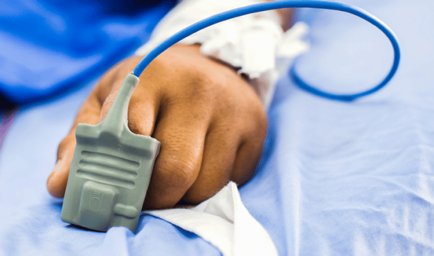 Hand of hospital patient with pulse camp on finger